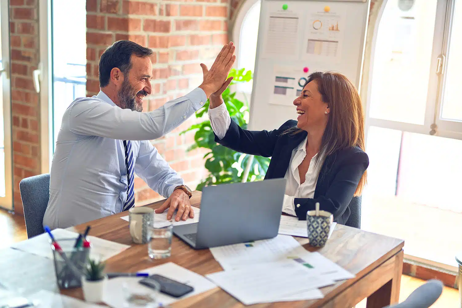 Business Professionals high fiving in the office